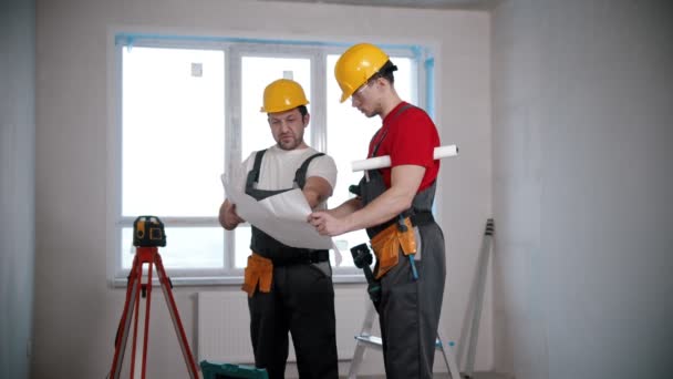 Apartment repair - two men workers discussing an apartment plan — Stockvideo