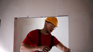 A man worker measuring length of the doorway