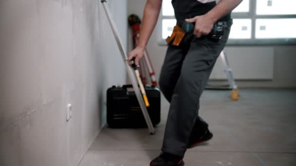 Um homem trabalha com uma chave de fenda em um soquete no apartamento rascunho — Vídeo de Stock