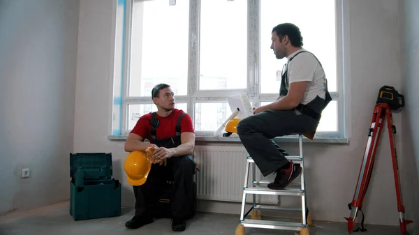 Mannen arbeiders met een pauze en het eten van cheesy roll en appel — Stockfoto