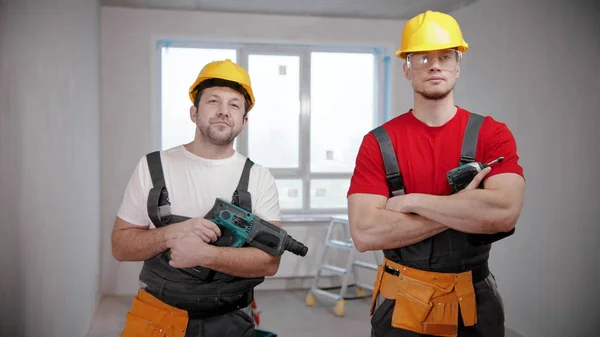 Twee fitte mannen staan in ontwerp appartement met instrumenten — Stockfoto