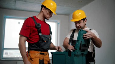 Two men workers pulling instruments out of the case