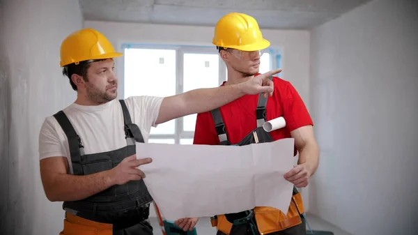 Twee mannen arbeiders kijken naar de lay-out — Stockfoto