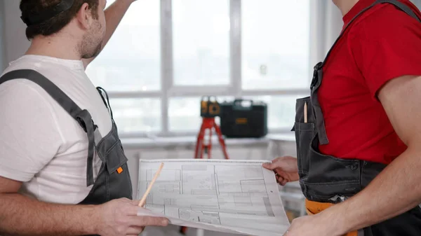 Two men workers looking at the layout — 图库照片