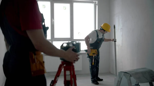 Reparatie van het ontwerp appartement - twee mannen werknemers die binnen werken — Stockfoto