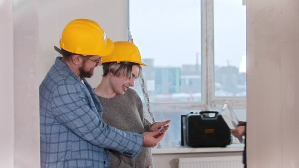 Une femme enceinte avec son mari regardant les clés du nouvel appartement un agent immobilier sautant et souriant en raison d'un accord réussi — Video