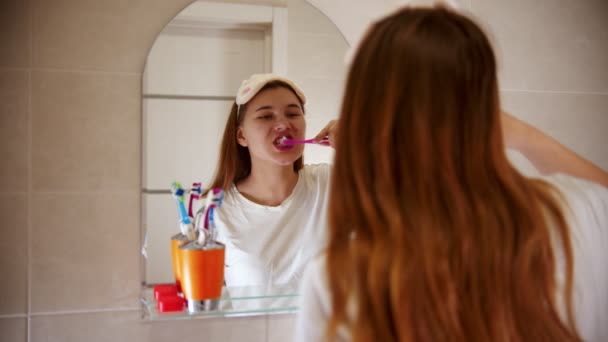 Uma jovem mulher escovando os dentes — Vídeo de Stock