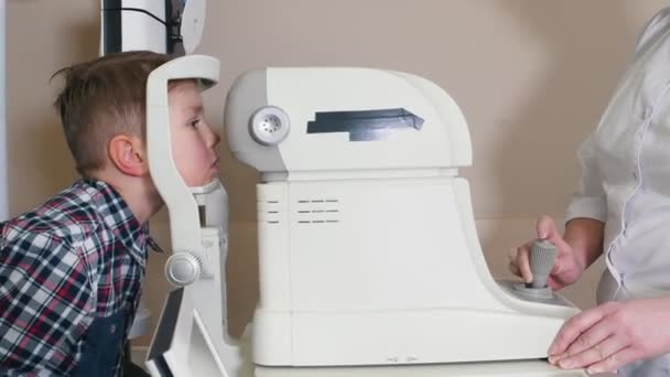 Oftalmólogo - mujer madura acariciando los ojos de los niños — Vídeos de Stock