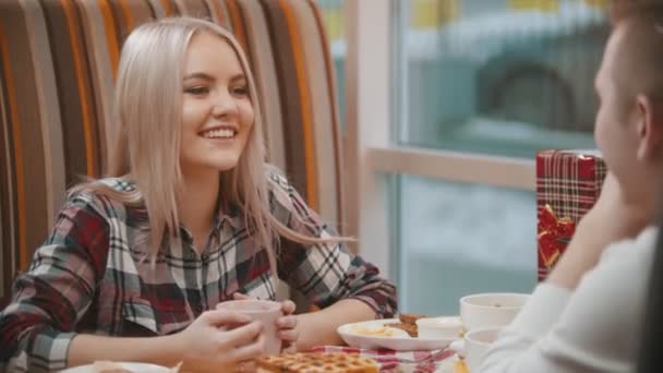 A young woman drinks coffee and talking with her boyfriend — Stock Video