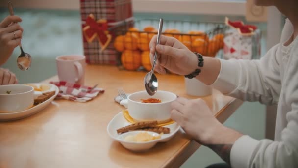 Una pareja en la cafetería almorzando y comiendo la papilla — Vídeos de Stock