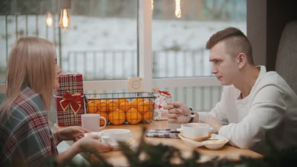 Een stel in een café lunchen in een restaurant en met elkaar praten - ober passeert — Stockvideo