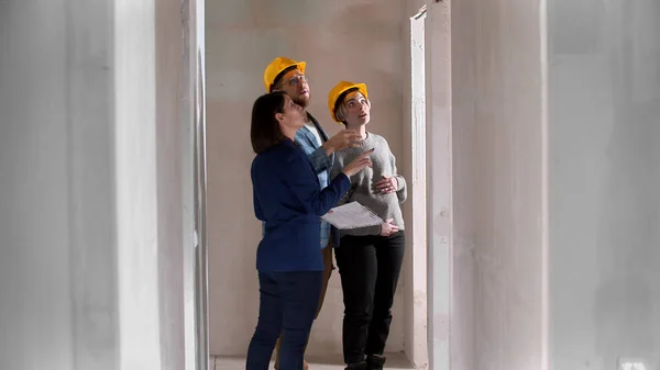 Un agent immobilier montrant un nouveau projet d'appartement à une famille - levant les yeux — Photo