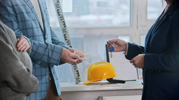 Familie praat met makelaar - een man vertelt geld voor de huur — Stockfoto