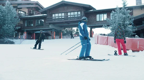 Snowboarding - osoby jeżdżące na łyżwach w pobliżu budynku bazy snowboardowej — Zdjęcie stockowe