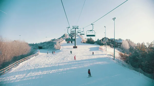 Snowboard concept d'hiver - funiculaire atteignant la gare - les gens snowboard en bas — Photo