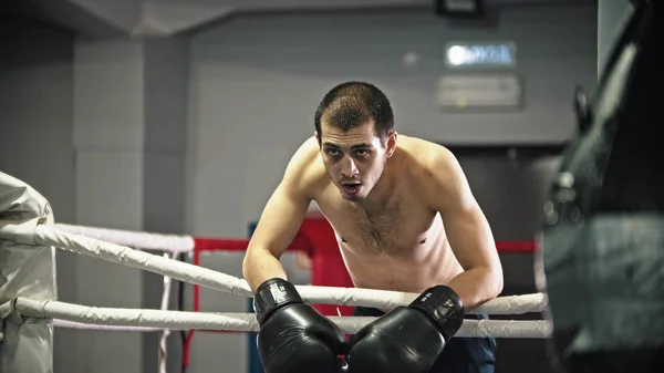 Ein müder Boxer, der sich am Ring lehnt — Stockfoto