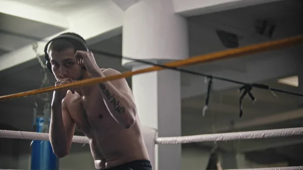 Um homem boxeador a treinar os seus golpes no ringue — Fotografia de Stock