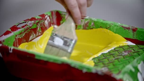 Mixing white and yellow colors in the paint tray using a brush — 비디오