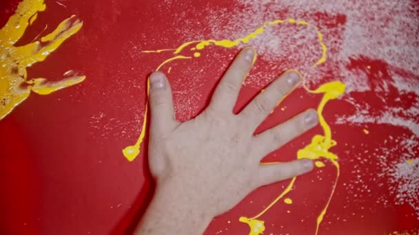 Poner una huella de la mano con un color amarillo en la pared roja — Vídeo de stock