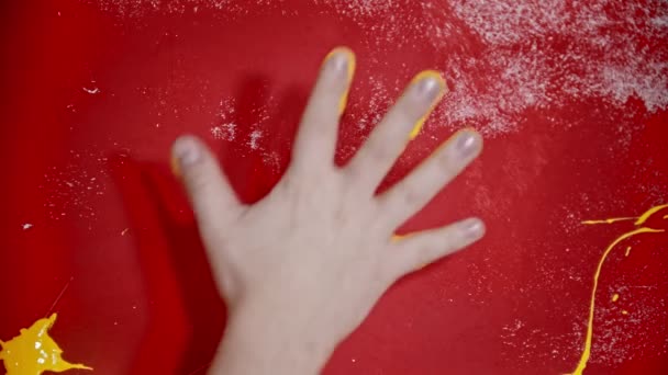 Βάζοντας ένα αποτύπωμα χεριού με έντονο κίτρινο χρώμα στον κόκκινο τοίχο — Αρχείο Βίντεο