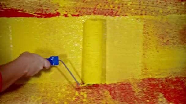 Dipingere una parete con un colore giallo usando un rullo — Video Stock