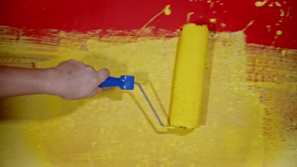 Handmålning en vägg med en gul färg färg med hjälp av en rulle — Stockvideo