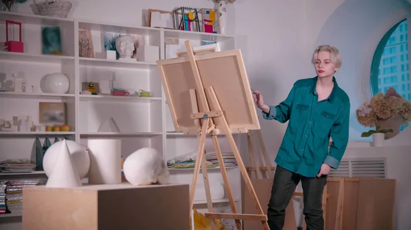 Una joven artista dibujando un cráneo y otras figuras de la mesa —  Fotos de Stock