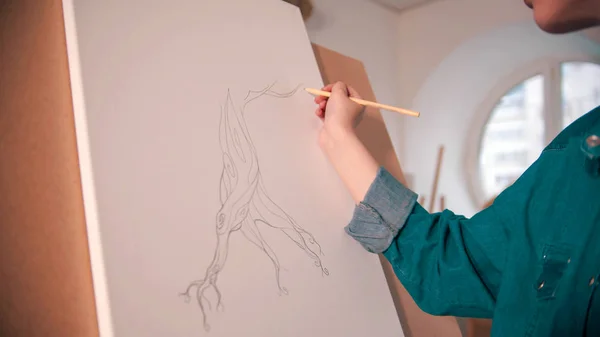 Una joven dibujando un árbol abstracto en el lienzo —  Fotos de Stock