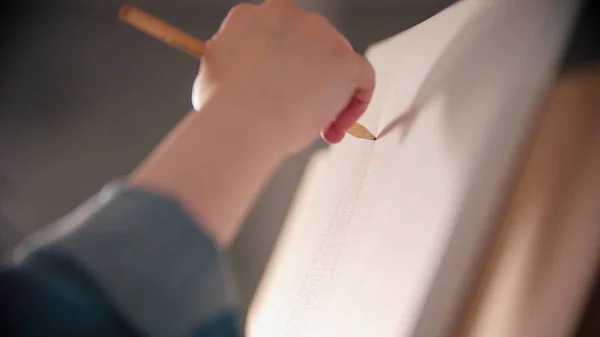Молодая женщина рисует на холсте карандашом — стоковое фото