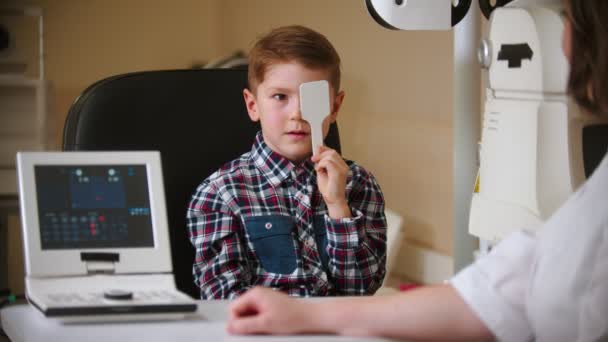 Een behandeling in oogkliniek - een kleine jongen die zijn oog bedekt met een oogschild — Stockvideo