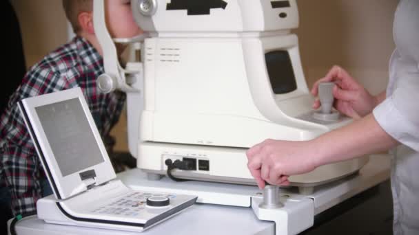 Garçon ayant un traitement en clinique oculaire - vérifier la vision oculaire des petits garçons en regardant à travers un grand dispositif spécial — Video