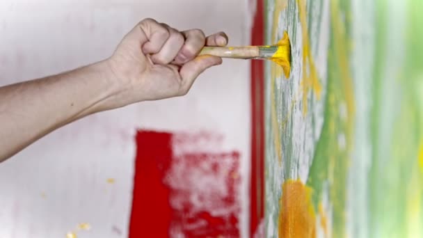 Mano escribe algo con una pintura amarilla en la pared — Vídeos de Stock