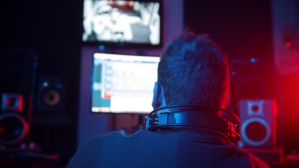 Un hombre ingeniero de sonido en los auriculares que trabajan en el estudio - grabación de una pista de rap — Vídeo de stock