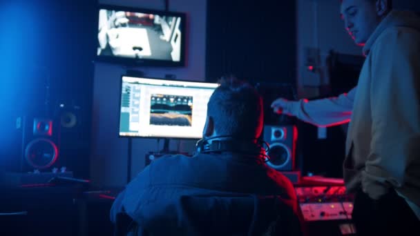 Een man geluidstechnicus en man rapper werken op de baan in de studio — Stockvideo