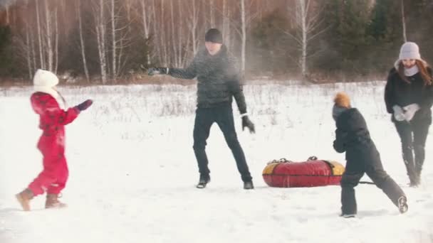 Familia lanzando nieve el uno al otro en invierno — Vídeos de Stock