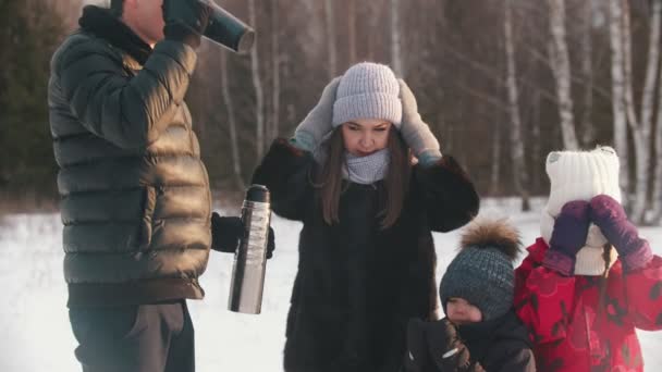 Семья пьет горячие напитки из термоса в зимнее время — стоковое видео