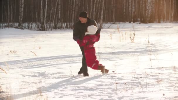 Uma mãe e um pai brincando com seus filhos ao ar livre no inverno — Vídeo de Stock