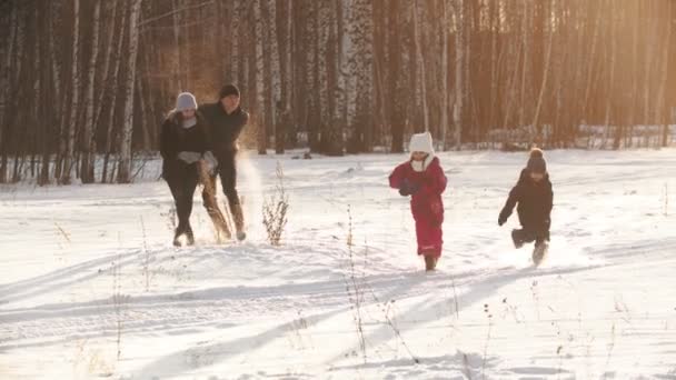 Family throwing snow on each other in winter time on sunset — ストック動画