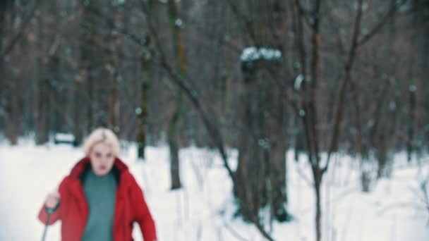 A young blonde woman hiking on the ski in the woods - lost and trying to find a way — Stockvideo