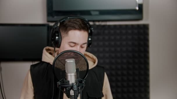 A young man rapper recording his track in the studio — ストック動画