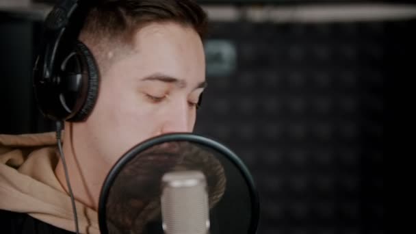 Ένας νεαρός ράπερ ηχογραφεί το τραγούδι του στο στούντιο ηχογράφησης — Αρχείο Βίντεο