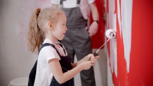 Dad teaching his daughter how to paint walls correctly — 图库视频影像