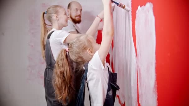 Family is laughing and painting red walls — ストック動画