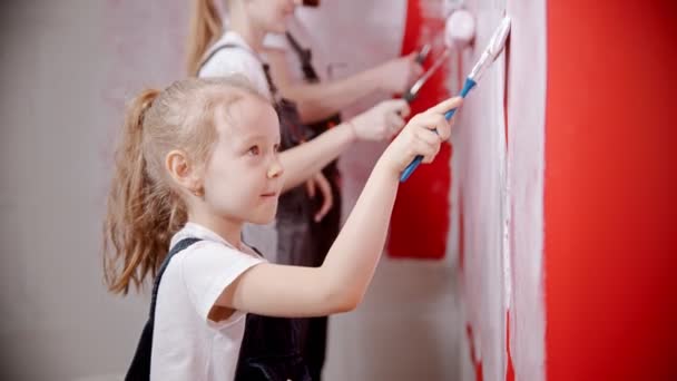 Το όμορφο κορίτσι βάφει τους τοίχους με γονείς. — Αρχείο Βίντεο