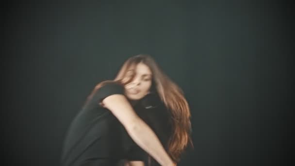 Μια νεαρή σέξι γυναίκα χορεύει σε σκοτεινό καπνιστό στούντιο — Αρχείο Βίντεο