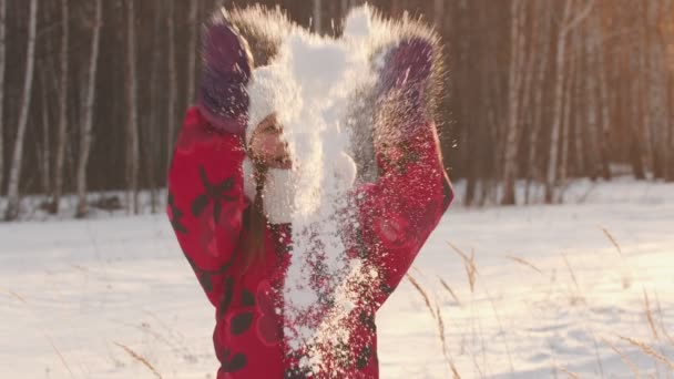 Gelukkig meisje gooit sneeuw in de lucht en glimlacht — Stockvideo