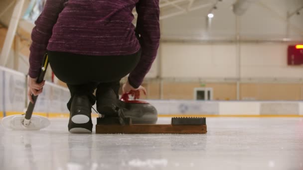 Curling training - a woman pushes the granite stone forwards — Stok video