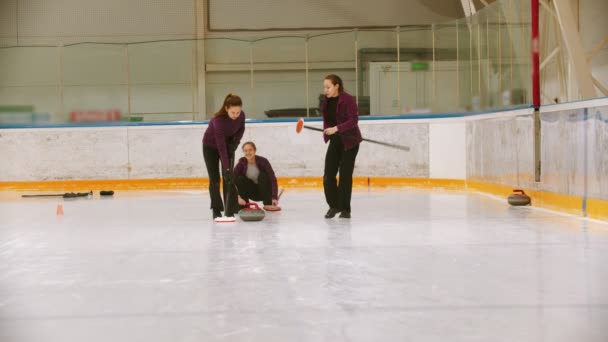 Curling training - leidende granieten steen op het ijs - wrijven het ijs voor de steen — Stockvideo