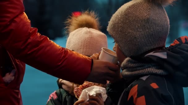 Τα παιδιά πίνουν ζεστά ροφήματα και τρώνε ντόνατς — Αρχείο Βίντεο