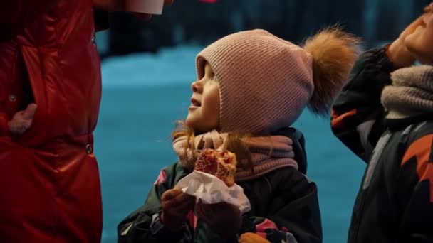 Niños tomando bebidas calientes y comiendo donas al aire libre — Vídeos de Stock